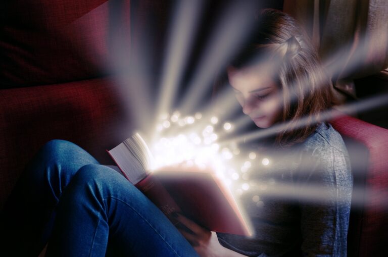 girl reading book with light coming off the page